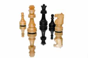 photo of black and beige wooden chess pieces with white background